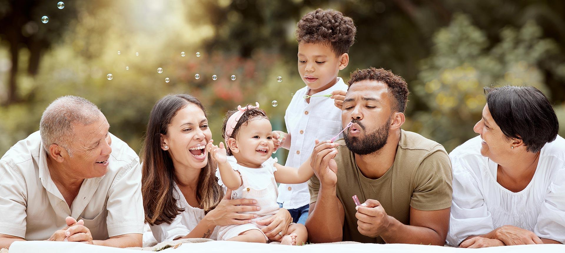 Intergenerational Family Blowing Bubbles in a Garden on a Summer Picnic